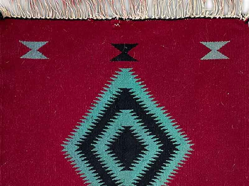 Germantown sampler rug. Original fringe; 4 corner medallions; maroon background with colors of turquoise and black